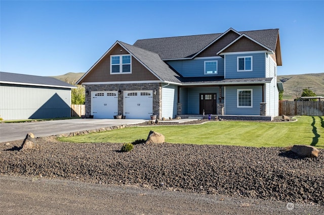 craftsman-style home featuring a front lawn, a garage, and a mountain view