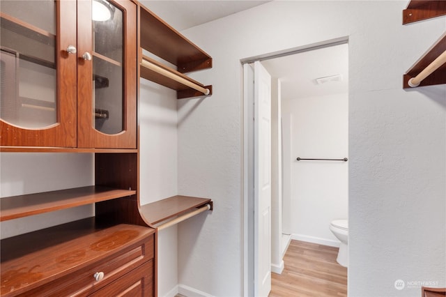 walk in closet with light wood-type flooring