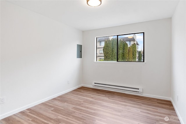 spare room with electric panel, baseboard heating, and light hardwood / wood-style flooring