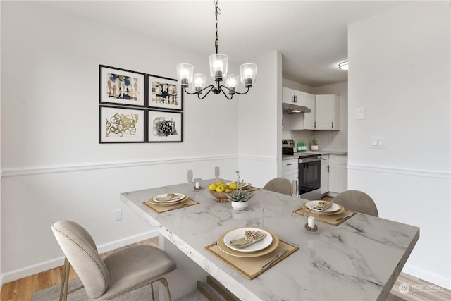 dining room with an inviting chandelier and light wood-type flooring