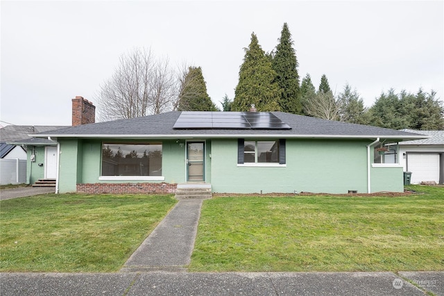 ranch-style home with solar panels, a front lawn, and a garage