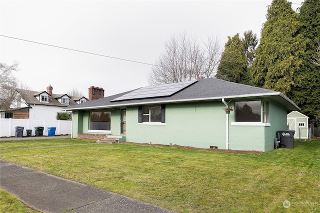 view of front of house featuring a front yard and solar panels