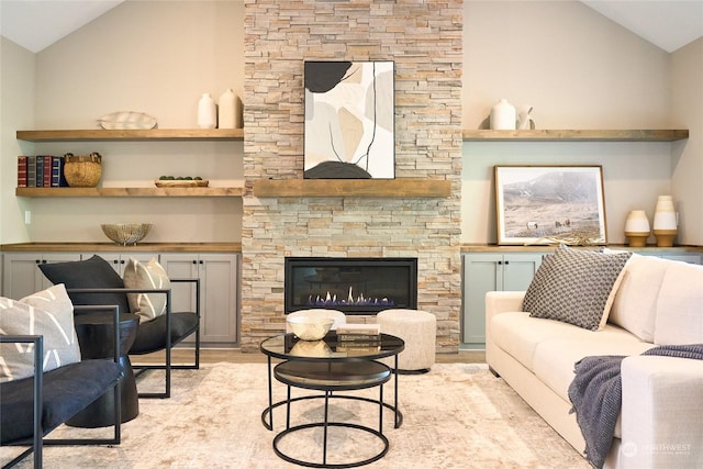 living room featuring light hardwood / wood-style flooring, vaulted ceiling, and a fireplace