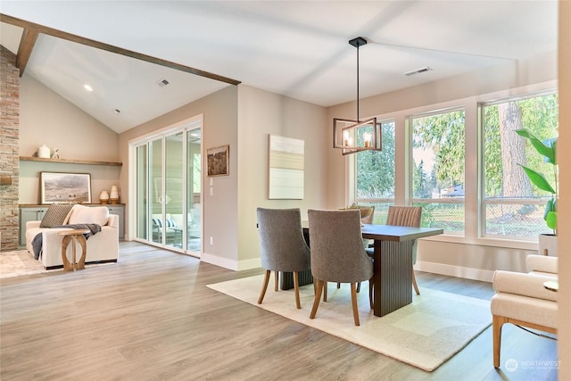 dining room with vaulted ceiling, a notable chandelier, and light hardwood / wood-style flooring