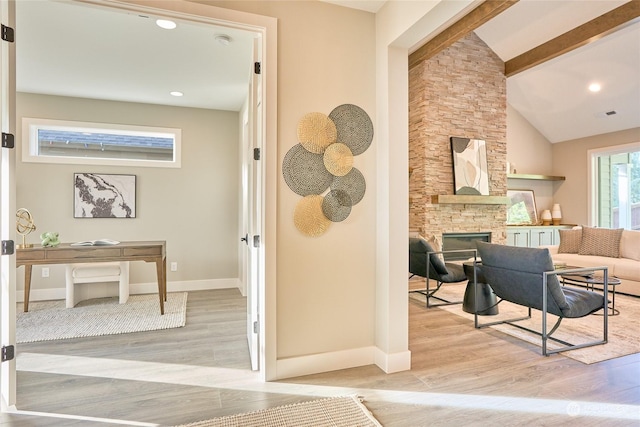 interior space featuring light wood-type flooring and lofted ceiling with beams