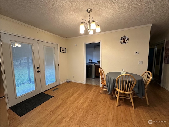 dining area with ornamental molding, light wood-type flooring, a notable chandelier, and french doors