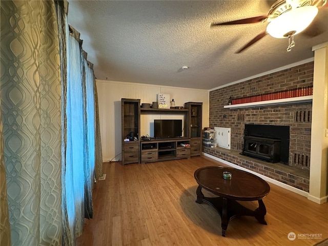 living room featuring a textured ceiling, a wood stove, and hardwood / wood-style flooring