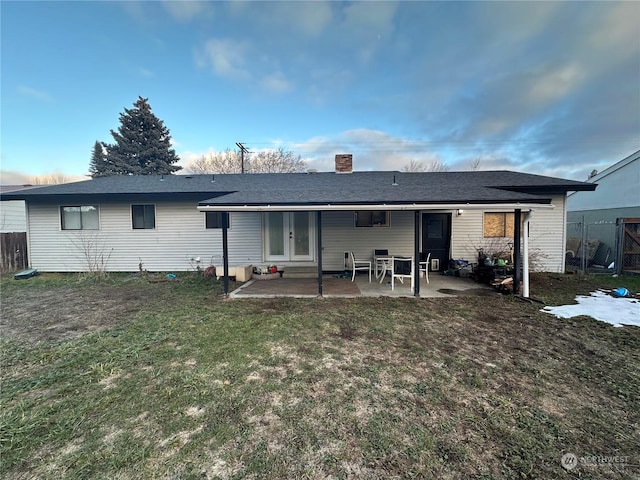 back of property with a lawn and a patio area