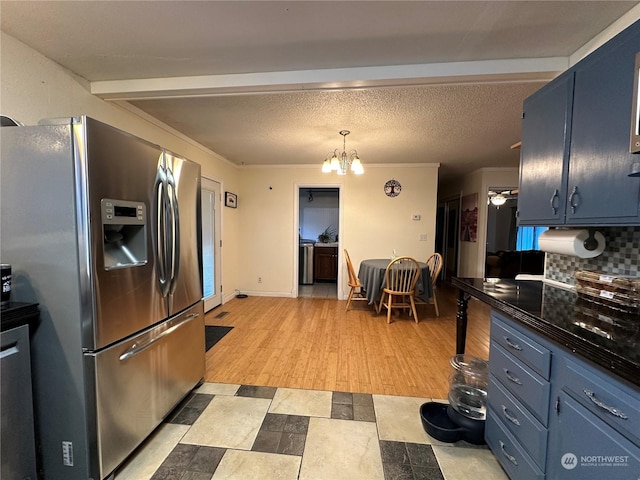 kitchen with decorative backsplash, blue cabinetry, a chandelier, and stainless steel fridge with ice dispenser