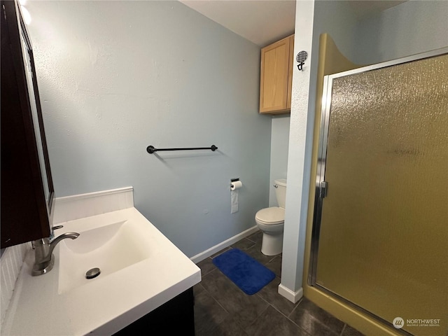 bathroom featuring toilet, a shower with door, tile patterned floors, and vanity