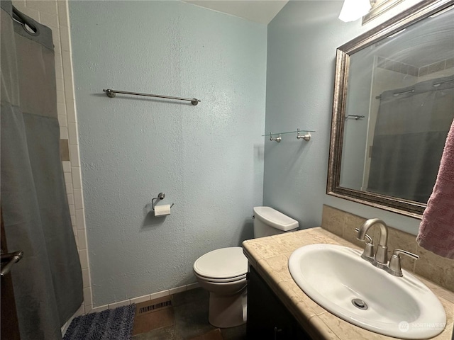 bathroom featuring tile patterned flooring, a shower with curtain, vanity, and toilet