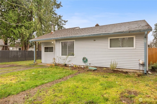 rear view of property featuring a lawn