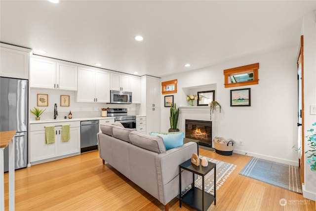 living room featuring sink and light hardwood / wood-style floors