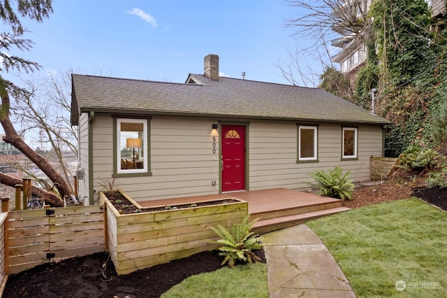 rear view of house featuring a lawn and a wooden deck