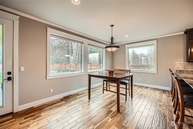 dining room featuring light wood finished floors, baseboards, ornamental molding, and recessed lighting