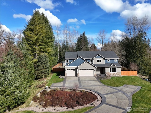 traditional home featuring fence, stone siding, concrete driveway, board and batten siding, and a front yard