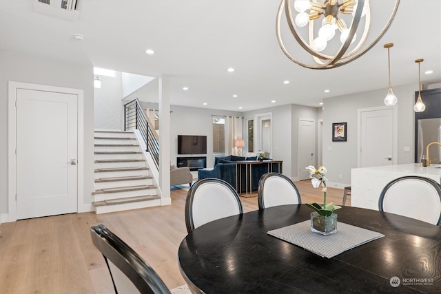 dining space featuring an inviting chandelier and light wood-type flooring