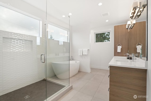 bathroom with tile patterned flooring, vanity, and plus walk in shower