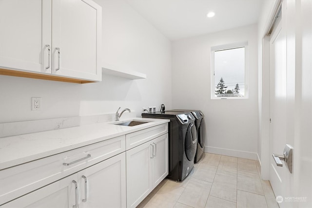 washroom featuring cabinets, washing machine and dryer, sink, and light tile patterned flooring