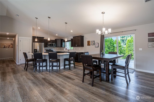 dining area featuring sink, dark hardwood / wood-style flooring, lofted ceiling, and a chandelier