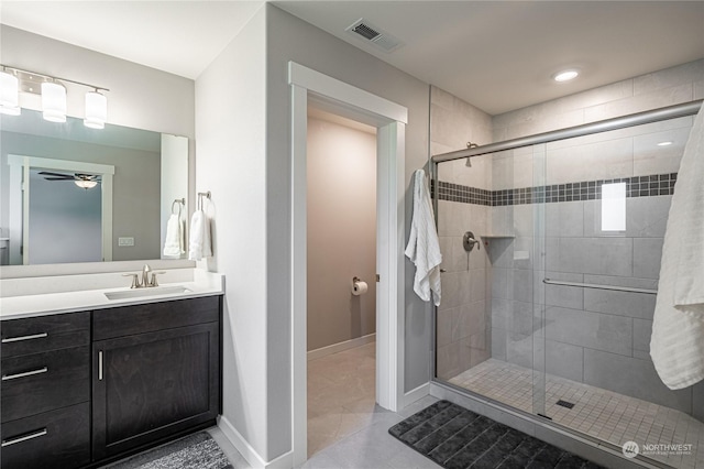 bathroom with ceiling fan, vanity, an enclosed shower, and tile patterned floors