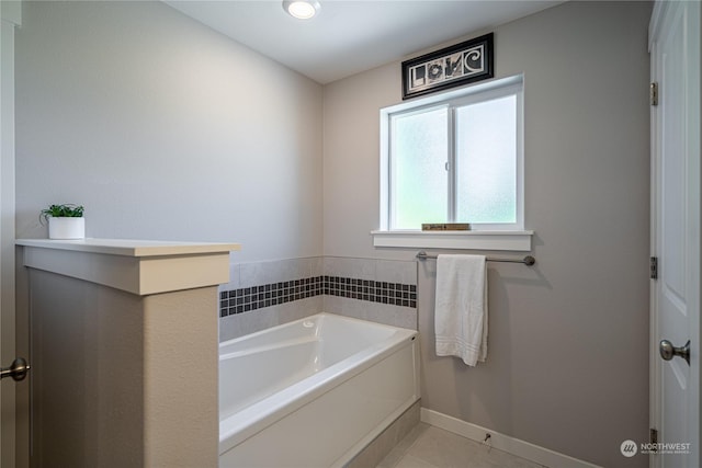 bathroom with a tub to relax in and tile patterned floors