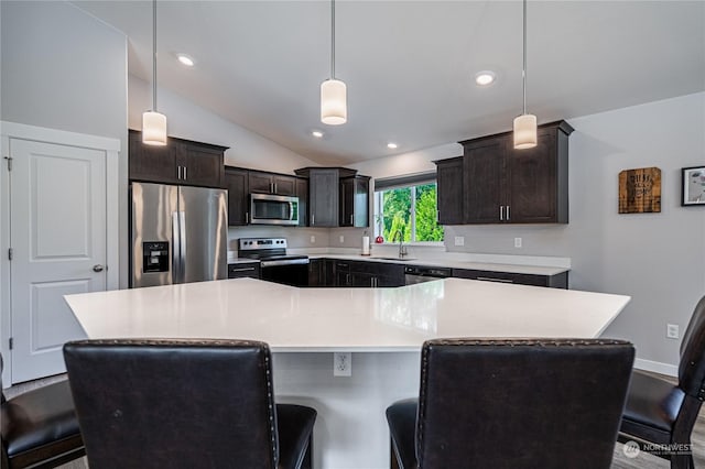 kitchen featuring sink, lofted ceiling, a spacious island, pendant lighting, and appliances with stainless steel finishes