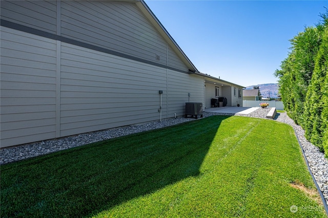 view of yard with central air condition unit and a patio