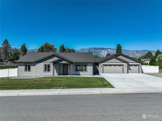 single story home featuring a front lawn, a garage, and a mountain view