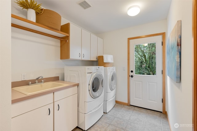 clothes washing area featuring cabinets, separate washer and dryer, sink, and light tile patterned floors