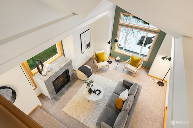 living room with carpet flooring, vaulted ceiling, and a tile fireplace