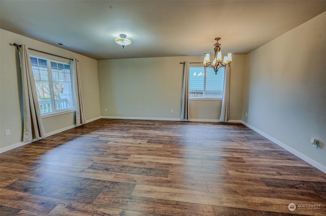 unfurnished room featuring dark hardwood / wood-style flooring and a notable chandelier