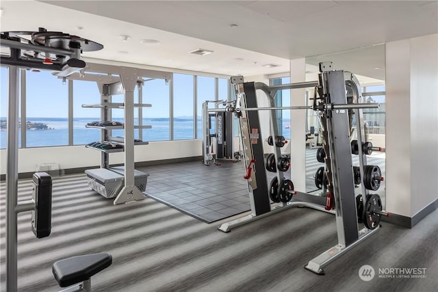 exercise room with a water view