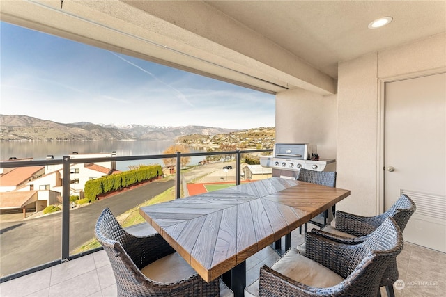 balcony featuring a water and mountain view and a grill