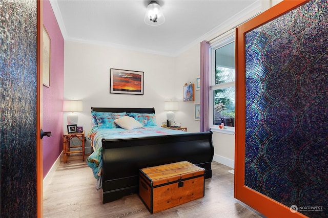 bedroom featuring crown molding and wood-type flooring