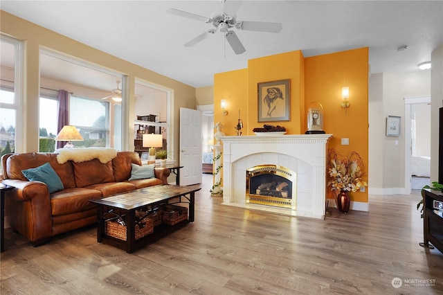 living room with ceiling fan, hardwood / wood-style floors, and a tile fireplace