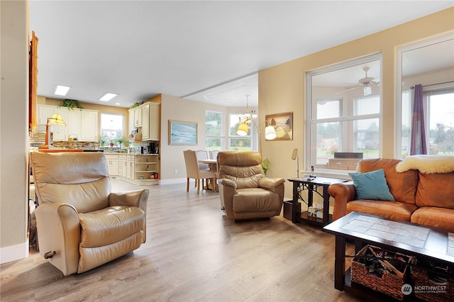 living room with ceiling fan, a healthy amount of sunlight, and light wood-type flooring