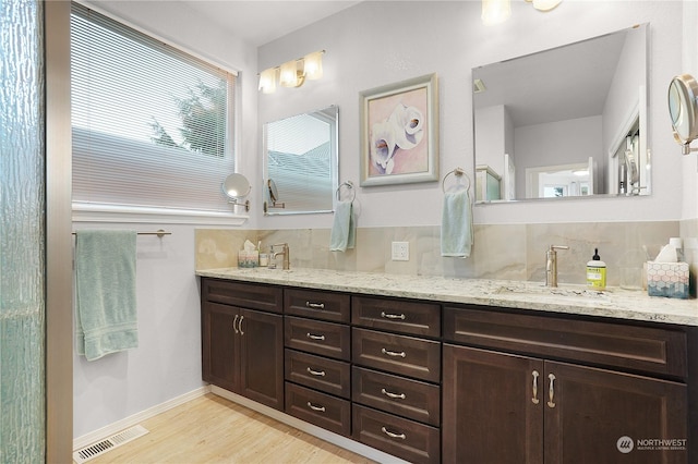 bathroom featuring hardwood / wood-style flooring, backsplash, and vanity