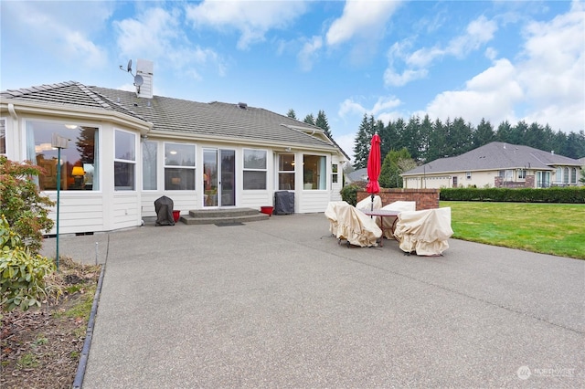 back of house featuring a patio area and a lawn