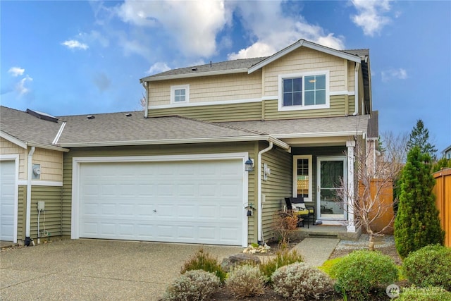 view of front facade featuring concrete driveway, fence, a garage, and roof with shingles