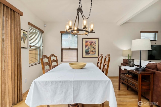 dining space with beamed ceiling, light wood-style floors, and an inviting chandelier