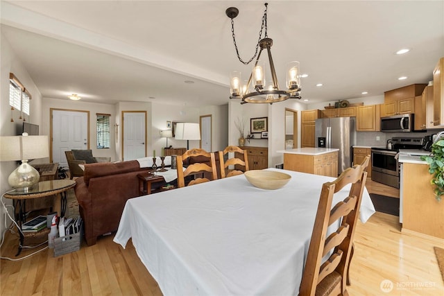 dining space with recessed lighting and light wood-style flooring