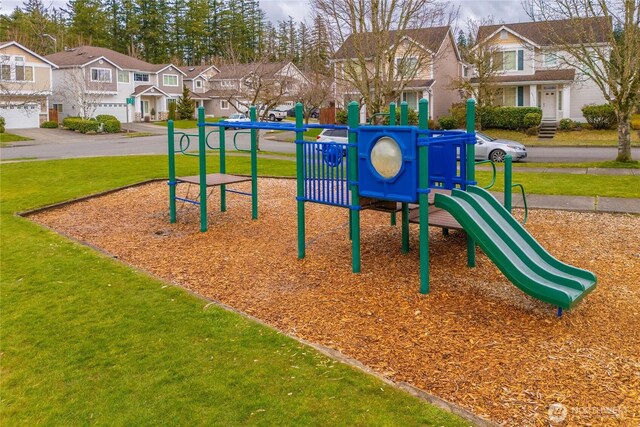 community jungle gym featuring a lawn and a residential view