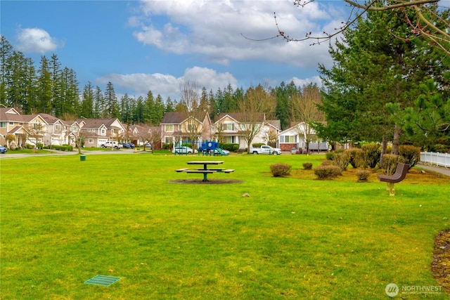 view of community with a residential view, a lawn, and playground community