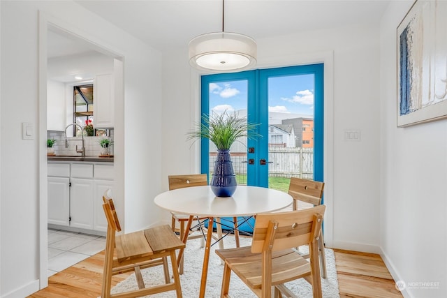 dining room featuring light hardwood / wood-style floors, french doors, and sink