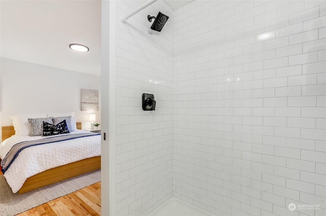 bathroom featuring a tile shower and hardwood / wood-style floors