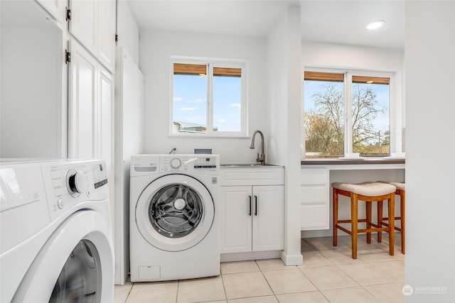 laundry room featuring light tile patterned floors, sink, separate washer and dryer, and cabinets