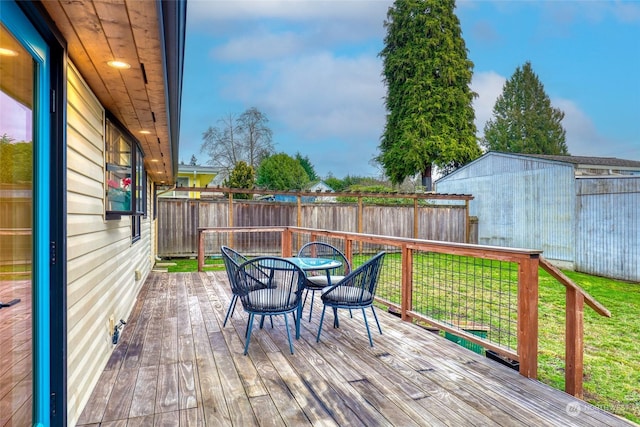 deck featuring a lawn and a storage unit