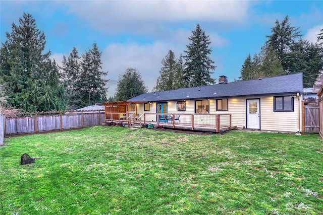 back of property featuring a deck and a yard