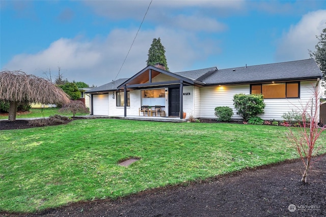 view of front of home with a front lawn and a garage